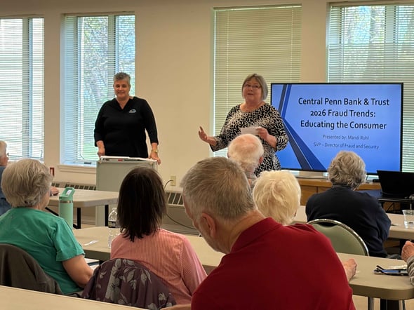 Two female Central Penn Bank employees give a presentation on Fraud Prevention to a group of senior citizens.