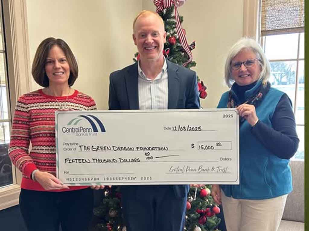 A Central Penn employee stands with a donation check to the Green Dragon Foundation with 2 of the organizations representatives.