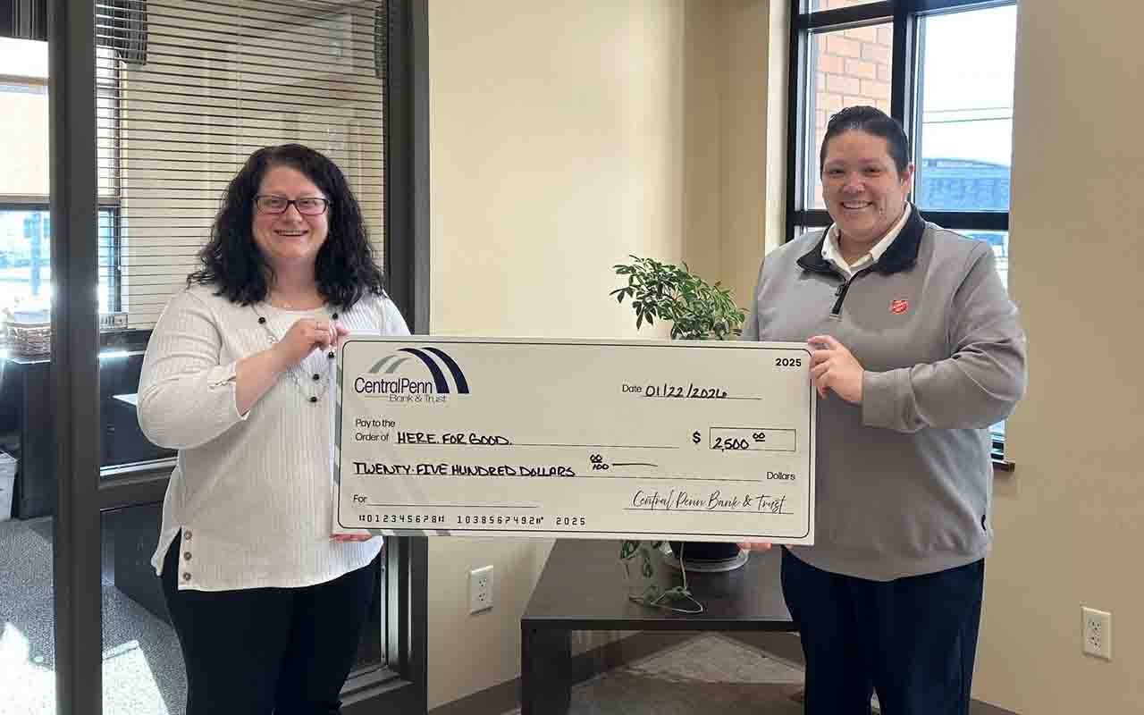 A Central Penn female employee gives a $2,500 donation to Here. For Good campaign representative.