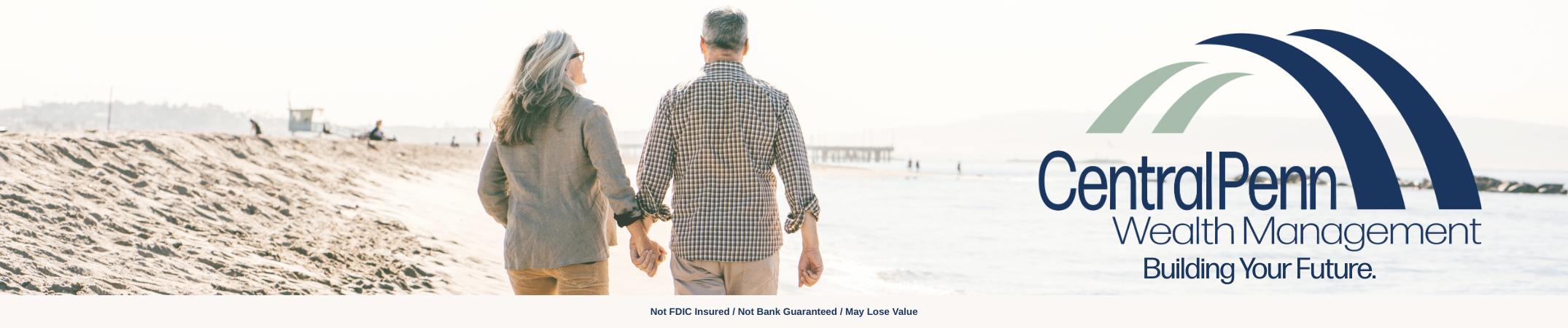 A man and woman walk on the beach hand in hand facing away from the camera with the Central Penn Wealth Management logo on the right side of the photo
